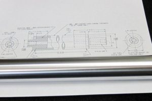 Piston from linear actuator repaired by hard chrome plating, shop drawing in the background